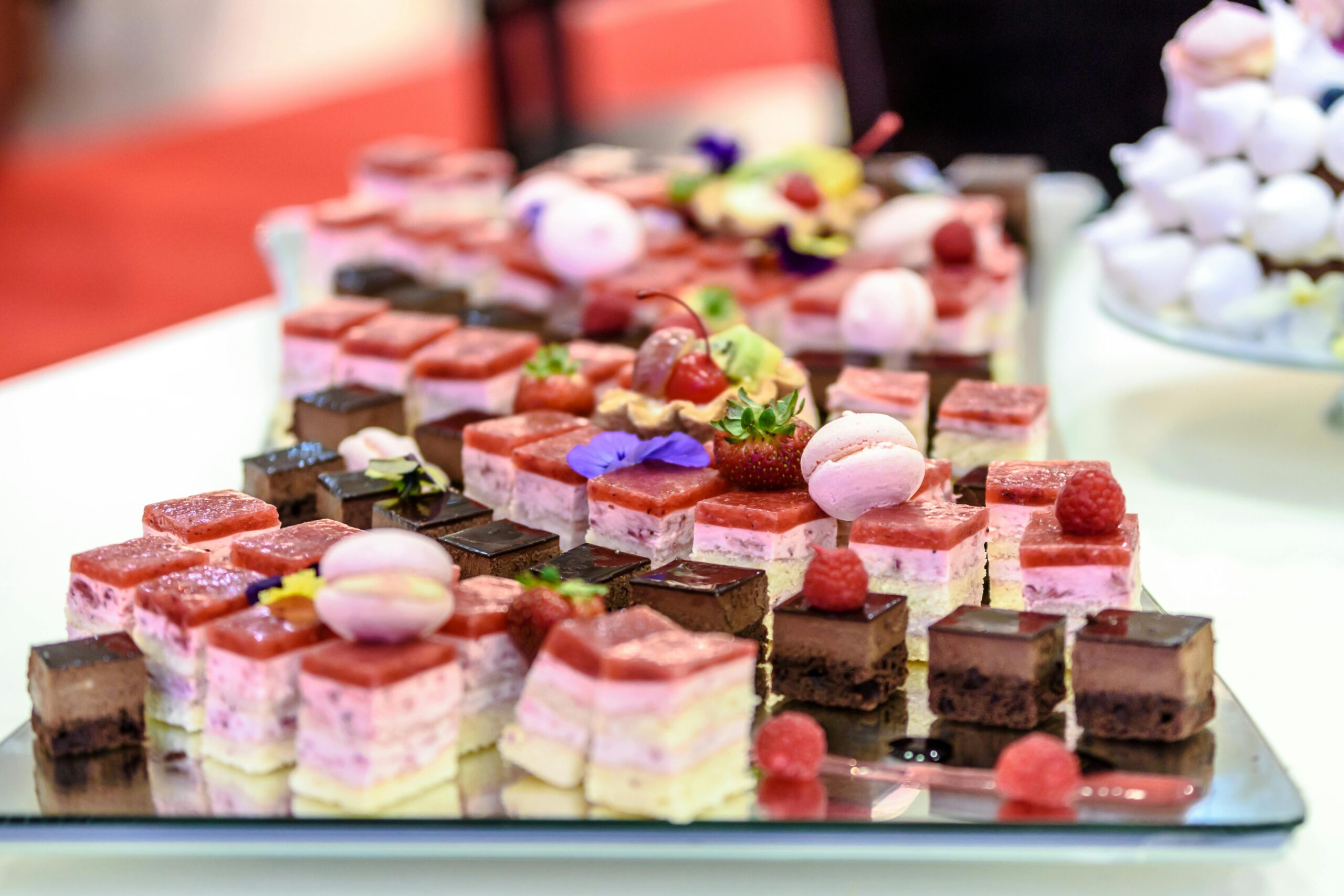 A delicious spread of colorful gourmet pastries and desserts served on a platter.